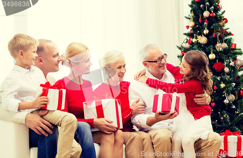 Image of smiling family with gifts at home