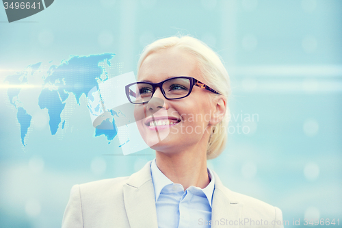 Image of young smiling businesswoman in eyeglasses outdoors