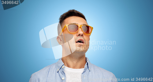 Image of face of scared man in shirt and sunglasses