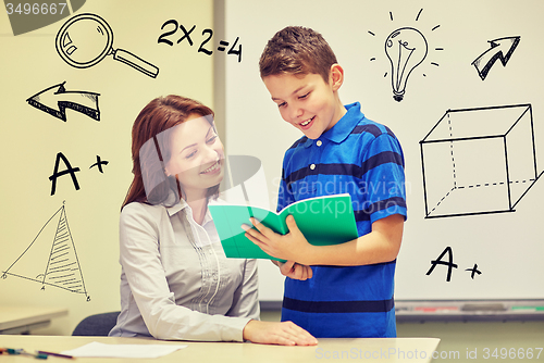 Image of school boy with notebook and teacher in classroom