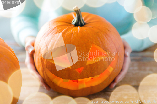 Image of close up of woman with pumpkins at home