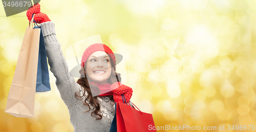 Image of happy woman in winter clothes with shopping bags