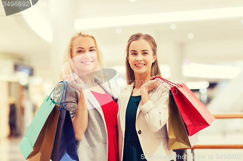 Image of happy young women with shopping bags in mall