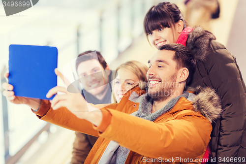 Image of happy friends with tablet pc on skating rink