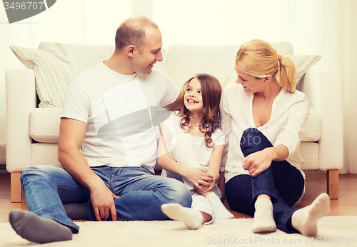 Image of parents and little girl sitting on floor at home