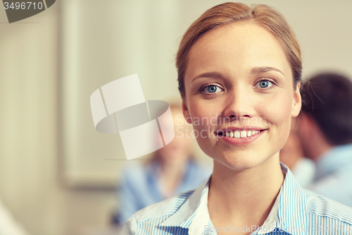 Image of group of smiling businesspeople meeting in office