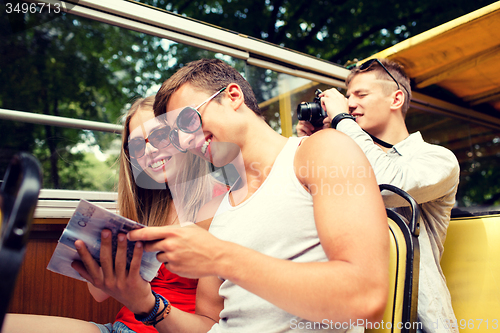 Image of smiling couple with book traveling by tour bus