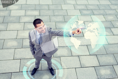 Image of smiling businessman with globe projection outdoors