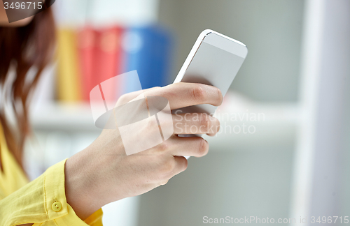 Image of close up of female hands with smartphone at home