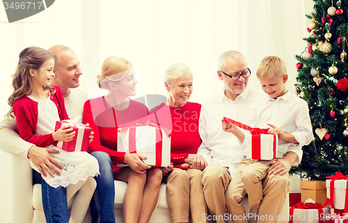 Image of smiling family with gifts at home