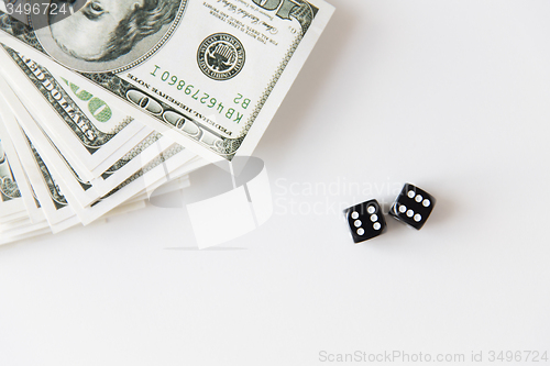 Image of close up of black dice and dollar money on table