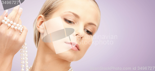 Image of beautiful woman with pearl necklace over violet