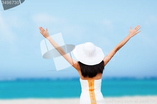 Image of girl with hands up on the beach