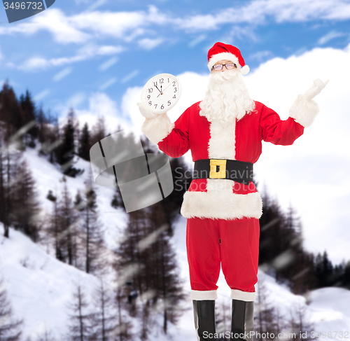 Image of man in costume of santa claus with clock