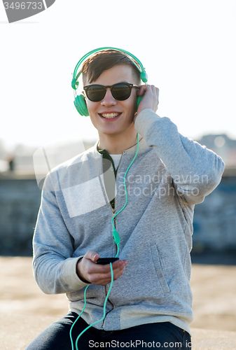 Image of happy young man in headphones with smartphone