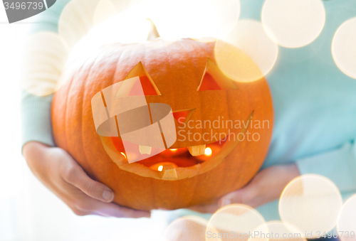 Image of close up of woman with pumpkins at home