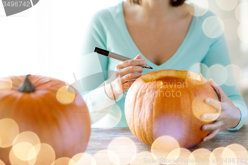 Image of close up of woman with pumpkins at home