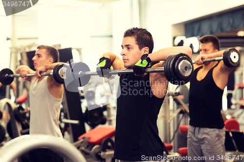 Image of group of men with barbells in gym