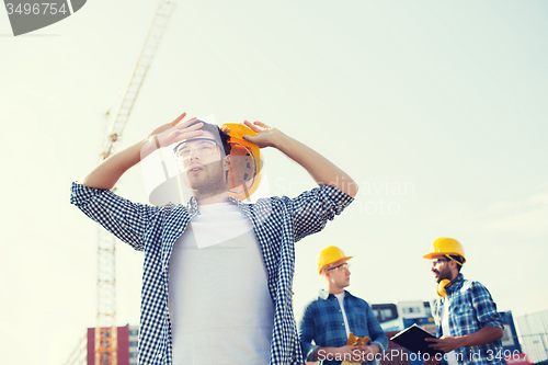 Image of group of builders in hardhats outdoors