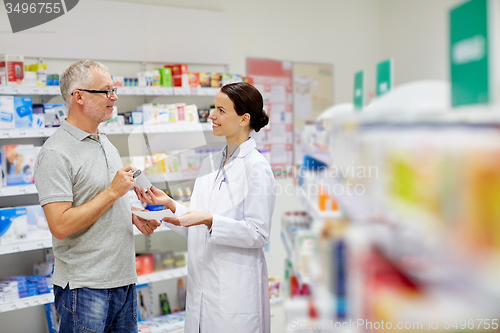 Image of pharmacist and senior man buying drug at pharmacy