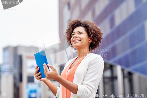 Image of happy african businesswoman with tablet pc in city