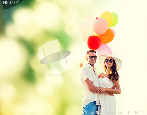 Image of smiling couple with air balloons outdoors