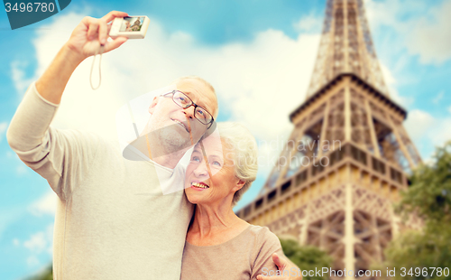 Image of senior couple with camera over eiffel tower