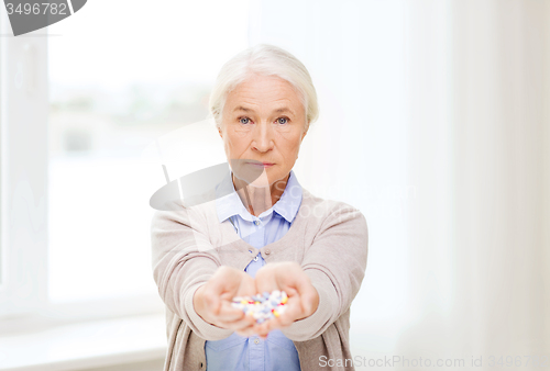 Image of senior woman with medicine at home