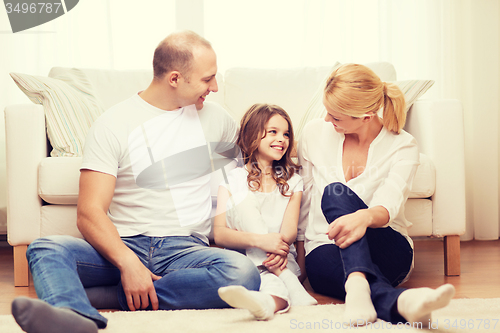 Image of parents and little girl sitting on floor at home
