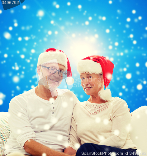 Image of happy senior couple in santa helper hats