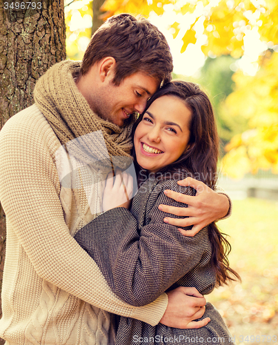 Image of smiling couple hugging in autumn park