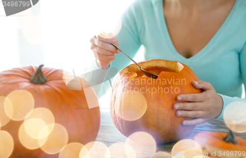 Image of close up of woman with pumpkins at home