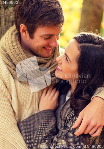 Image of smiling couple hugging in autumn park