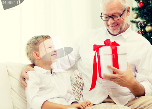 Image of smiling grandfather and grandson at home