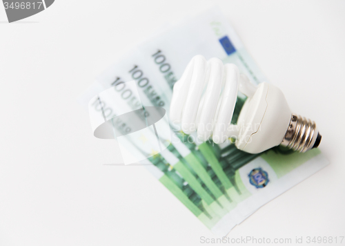 Image of close up of euro money and lightbulb on table