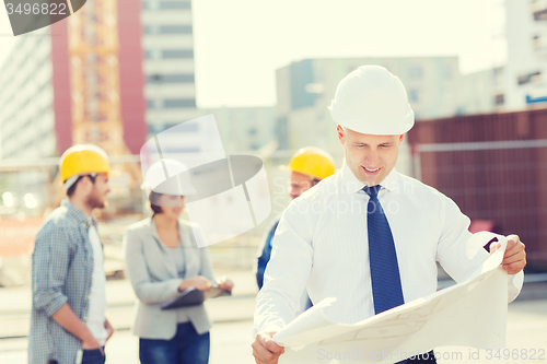 Image of group of builders with tablet pc and blueprint