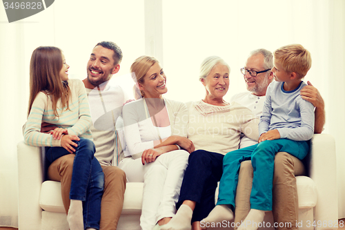 Image of happy family sitting on couch at home