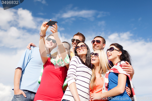 Image of group of friends taking selfie with cell phone