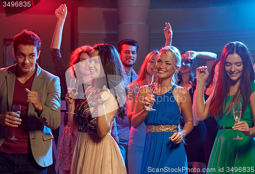 Image of smiling friends with glasses of champagne in club