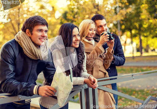 Image of group of friends with map and camera outdoors