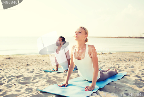 Image of couple making yoga exercises outdoors