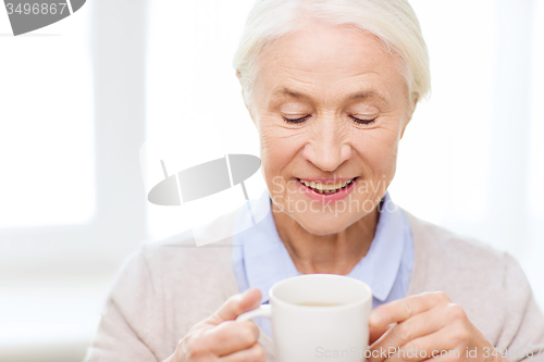 Image of happy senior woman with cup of tea or coffee