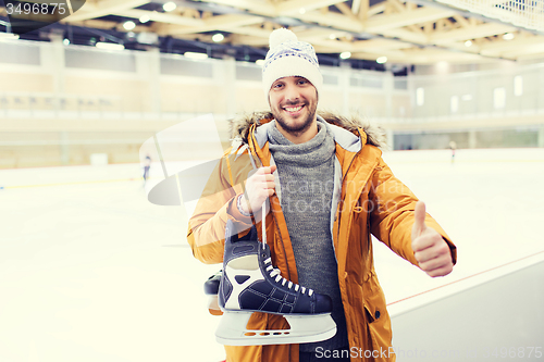 Image of happy young man showing thumbs up on skating rink