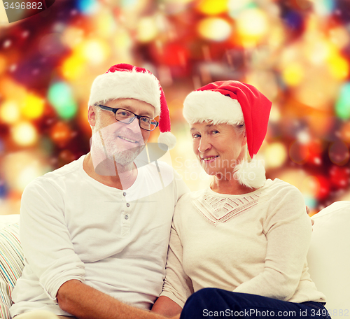 Image of happy senior couple in santa helper hats