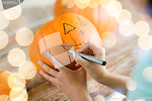 Image of close up of woman with pumpkins at home