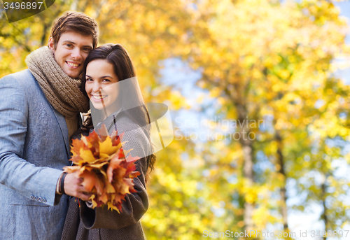 Image of smiling couple hugging over autumn background