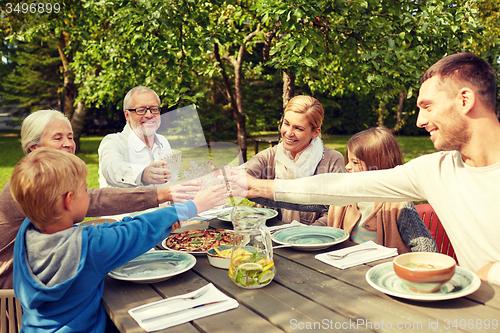 Image of happy family having dinner in summer garden