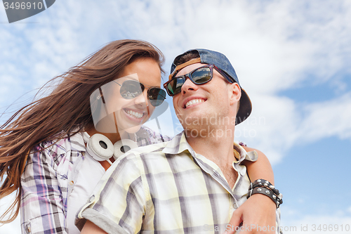 Image of smiling teenagers in sunglasses having fun outside