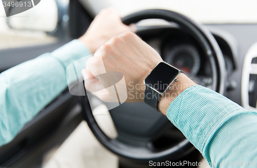 Image of close up of man with wristwatch driving car