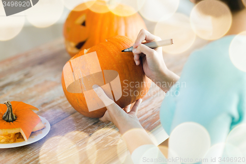 Image of close up of woman with pumpkins at home